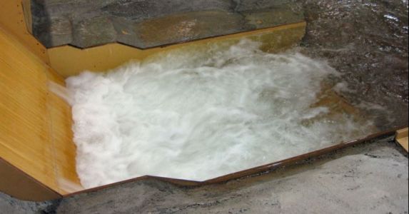 A hydraulic jump in a 1:48-scale model of a Type V still basin for a spillway.